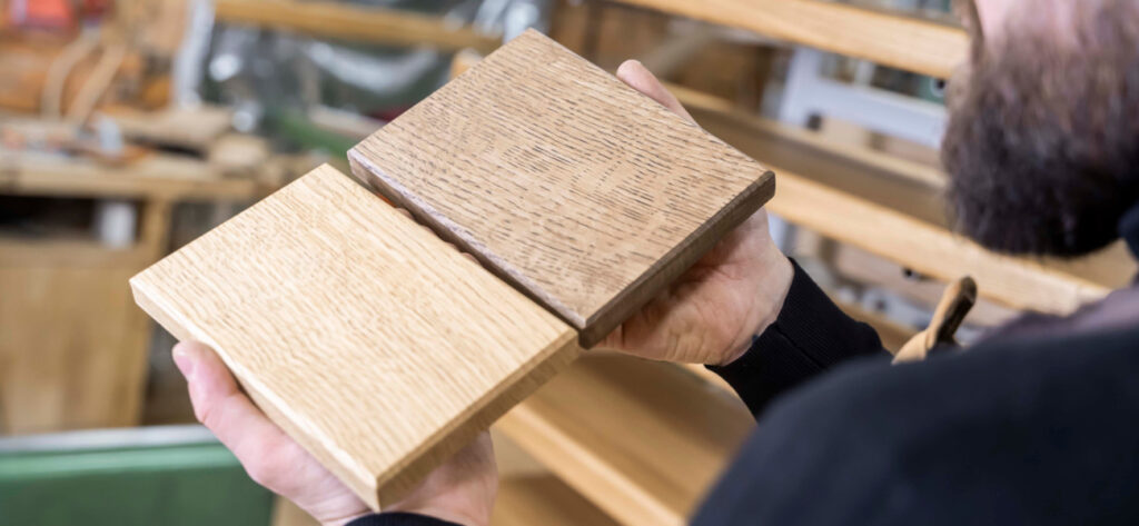 Stolarz Radosław Grabski porównuje próbki drewna jesion i dąb